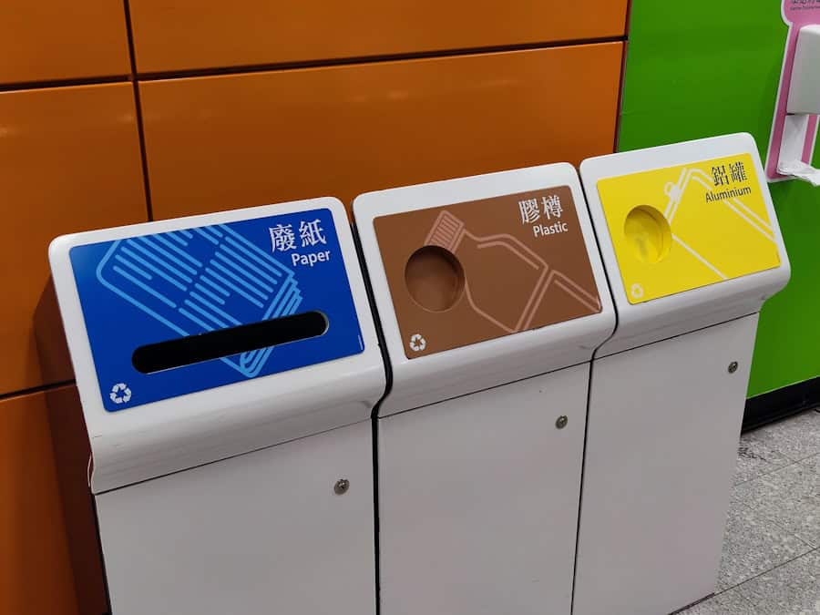 Recycling bins for paper, plastic, and aluminum waste at an eco-friendly home or public recycling facility; promoting waste separation.