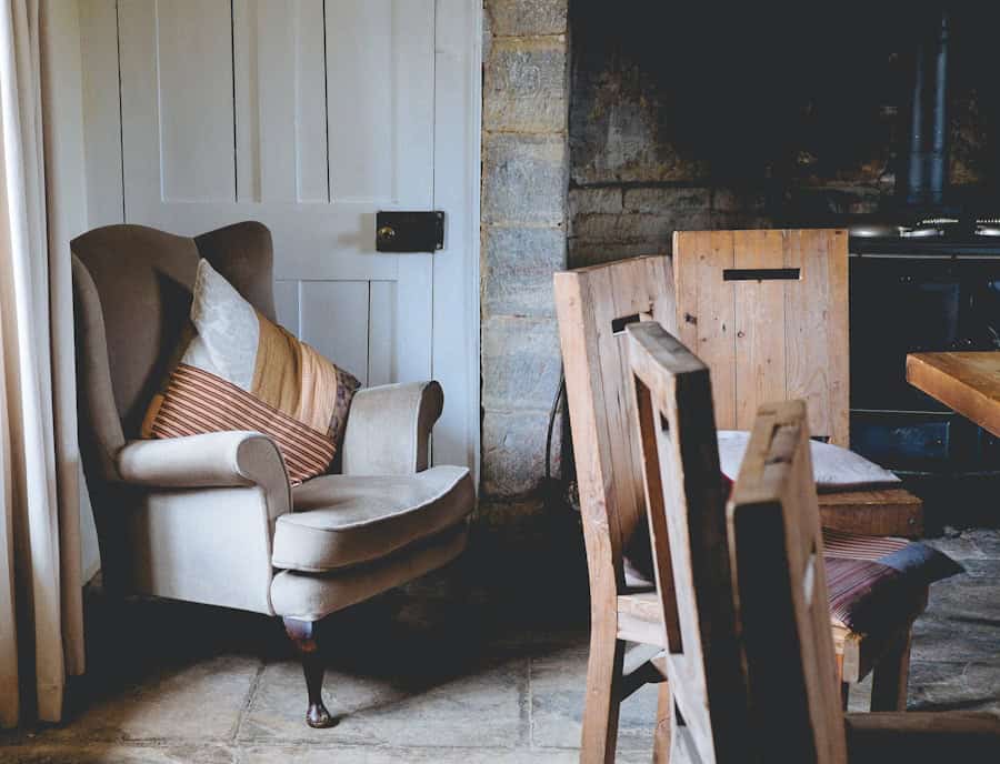 Cozy rustic living room with vintage armchair and wooden dining chairs, eco-friendly home decor, natural materials, sustainable interior design, eco-conscious lifestyle, eco home interior, environmentally friendly furnishings.